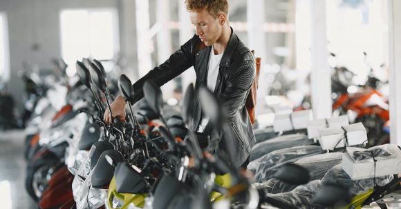 Motorcycle License Test - Man in Black Leather Jacket Looking at a Motorcycle