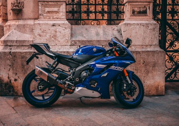 Motorcycle - parked blue sports bike near black metal gate