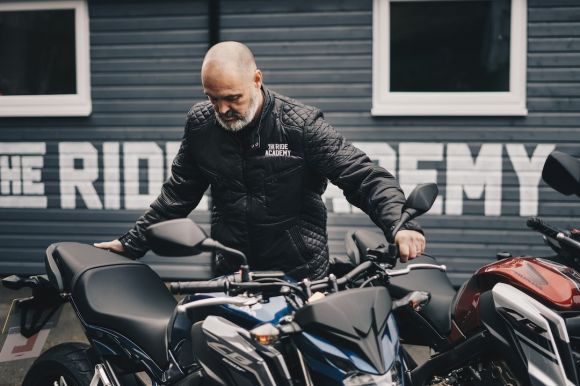 Rain Motorbike - man holding black Honda CB motorcycle