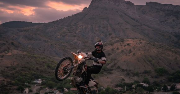 Moto Riding - A Person Driving a Dirt Bike in Mid Air