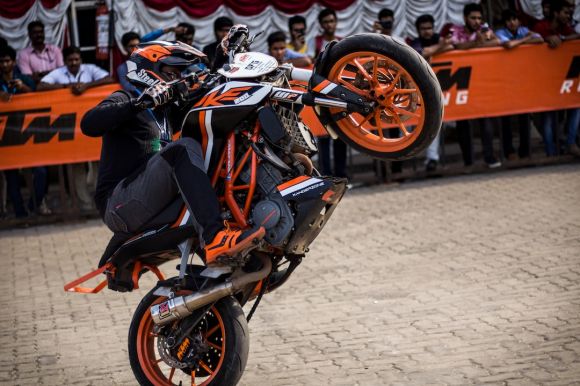 Sport Motorbikes - person riding black and white Duke 390 dirt bike on concrete pavement outdoor during daytime