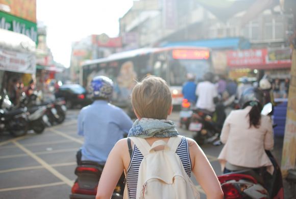 Motorcycle Insurance - woman wearing backpack walking on road