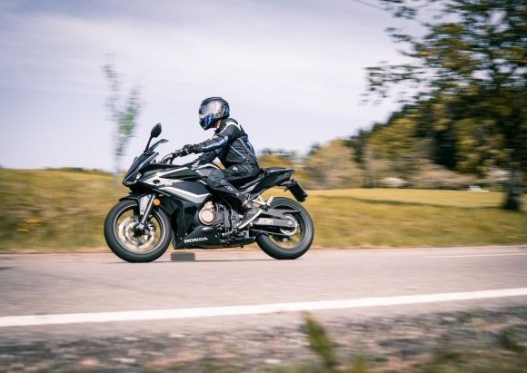 Motorcycle Helmet - man in black jacket riding black sports bike on road during daytime