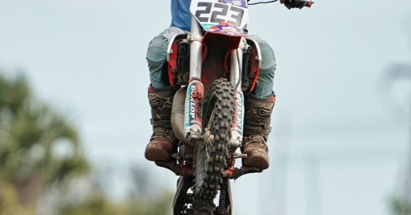 Motorcycle Tires: Terrain Selection. - Motorcyclist Jumping during Motocross Race