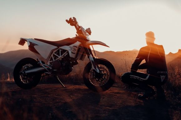 Moto Jacket - man in black jacket sitting on motorcycle during sunset