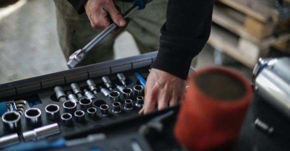 Engine Size - Crop mechanic choosing metal tools for repair in garage