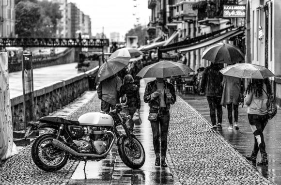 Rain Motorbike - person under umbrella beside motorcycke