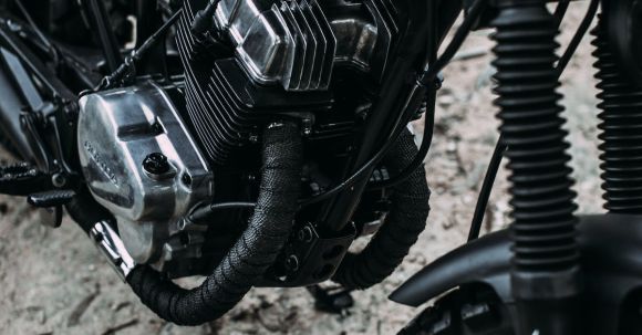 Moto Riding - Black shiny motorcycle parked on sandy road in summer day in nature outside