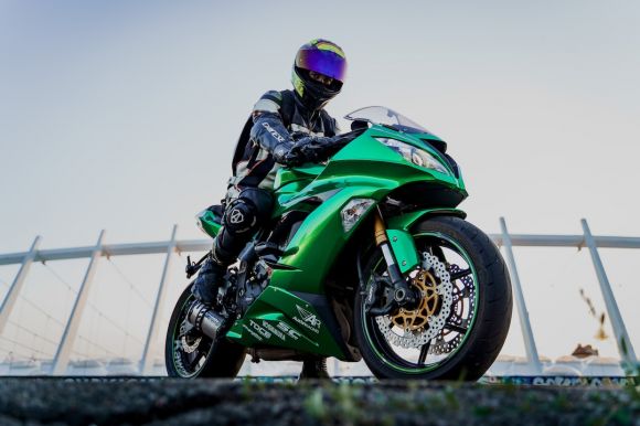 Motobike - man in green and black motorcycle suit riding on green and black sports bike