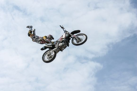 Motorbike In Garage - low angle photography of motocross player performing motocross flying style