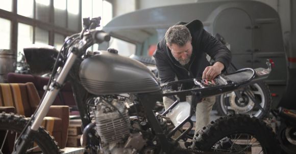 Motorcycle Maintenance - Man in Black Jacket Standing Near Black Motorcycle