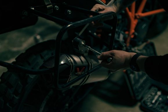 Moto Maintenance - a close up of a person working on a motorcycle