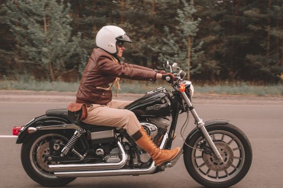 Motorcycle Helmet - man in brown leather jacket riding on black motorcycle during daytime