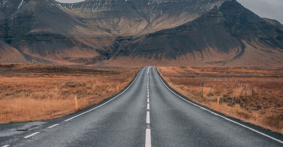 Lane Sharing: Allowed - Empty Highway Overlooking Mountain Under Dark Skies