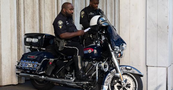 Motorcycle Laws - Standing Police Man Beside Another Man Who Seats of Police Motorcycle