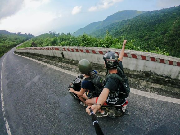 Motorcycle Trip - fish eye photography on woman riding motor scooter with man on bridge
