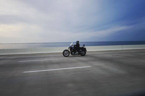 Water Moto Riding - person riding touring motorcycle on gray concrete road