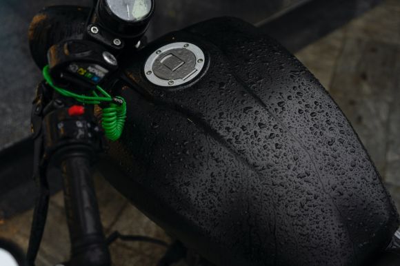 Rain Moto - a close up of a motorcycle handlebar with water droplets on it