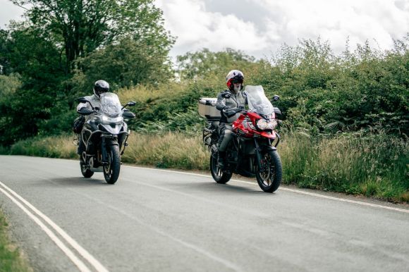 Motorcycle Group Trip - two motorcyclists riding down a country road