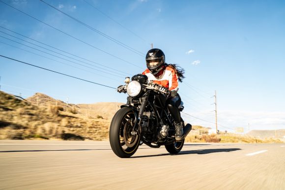 Moto Shoes - a person riding a motorcycle on a road