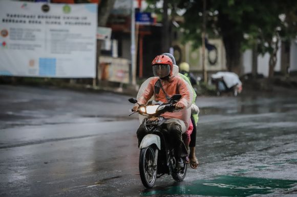 Wet Weather Motorcycle - a man riding a scooter