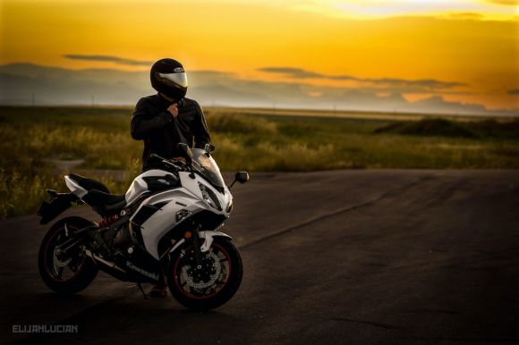 Motorcycle Helmet - man in black jacket riding white sports bike on road during daytime