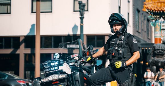 Motorcycle Protection - Policeman in a Uniform Standing by His Motorcycle