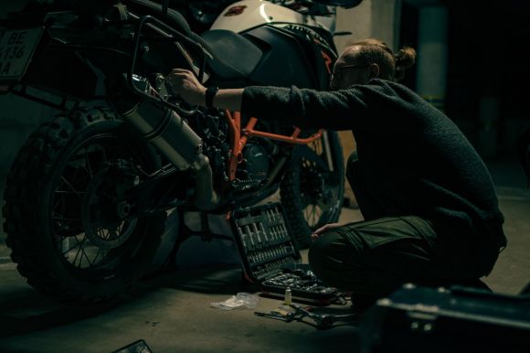Motorcycle Insurance - a man working on a motorcycle in a garage