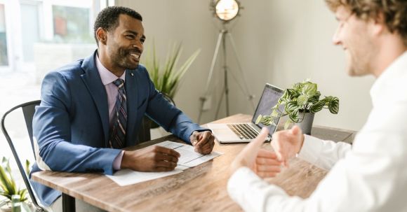 Insurance Consequences - Men Sitting at Table Smiling