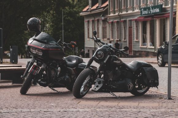 Motorcycle Helmet - black and red sports bike parked beside brown concrete building during daytime