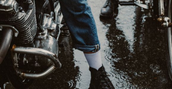 Motorcycle Rain Pants Considerations - A Person in Denim Pants Riding a Motorcycle