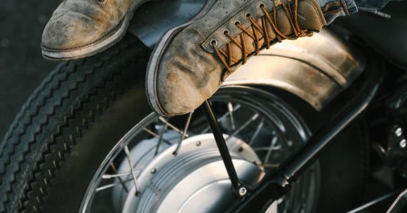 Motorcycle Footwear Considerations - Man Resting His Legs on a Wheel of a Motorbike