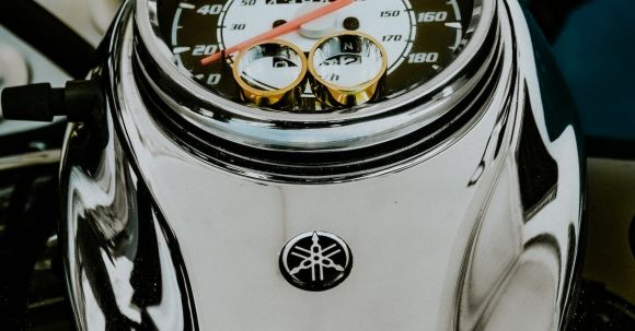 Motorcycle Exclusions. - From above fancy golden wedding rings placed on contemporary powerful motorbike speedometer for proposal